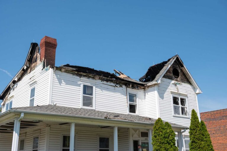 Fire-damaged residential home with burned roof and structural damage, requiring professional fire damage restoration services in Staten Island, NY
